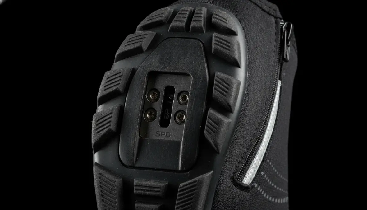 Cycling overshoe cleat compatibility and closure system detail for proper fit